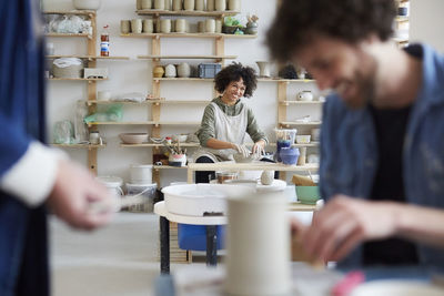 Portrait of smiling woman learning pottery in art class