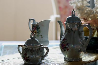 Close-up of teapot by container on table
