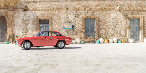 Red car agaist building