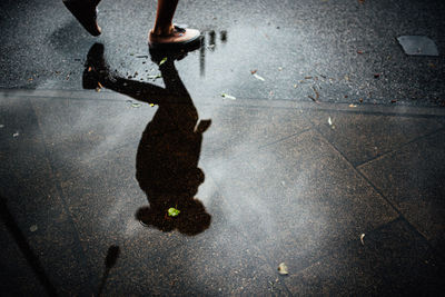 Low section of person walking on wet street