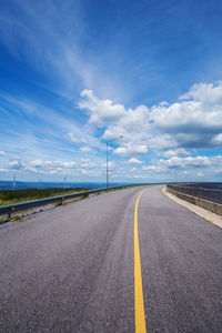 Empty road against cloudy sky