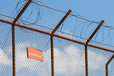 Low angle view of chainlink fence against sky