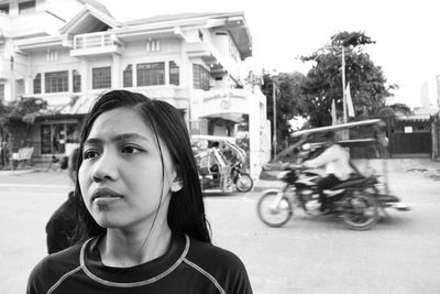 Teenage girl looking away while standing on street