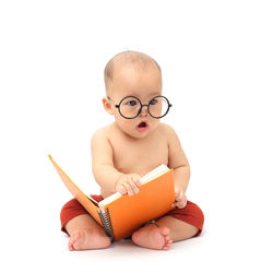 Portrait of cute baby girl sitting against white background