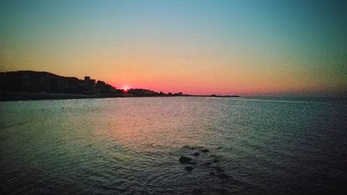 Scenic view of sea against clear sky at sunset