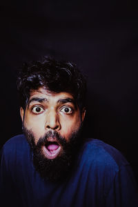 Portrait of young man against black background