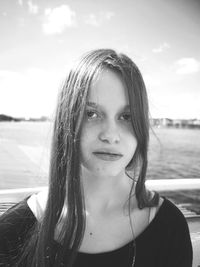 Close-up portrait of young woman against sea