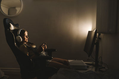 Pre-adolescent girl playing video game over television at home