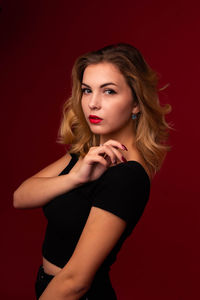 Portrait of a beautiful young woman over red background