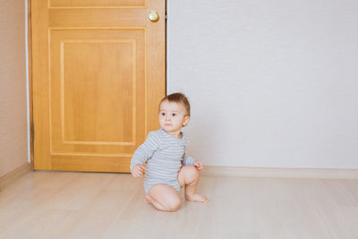 Portrait of cute girl sitting on floor at home