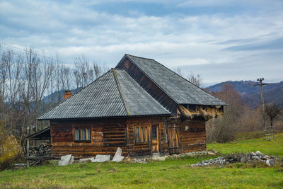 Abandoned house on field against sky