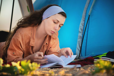 Portrait of young woman sitting on tent