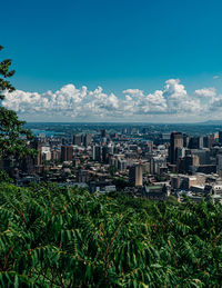 Panoramic view of city buildings against blue sky