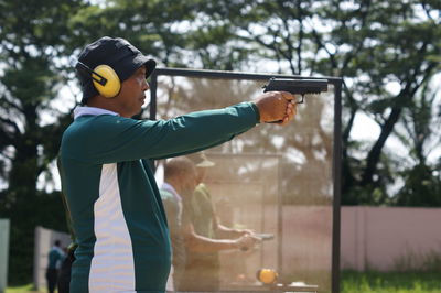 A man standing to shooting on target