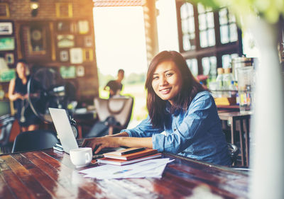 Young woman sitting on table at cafe