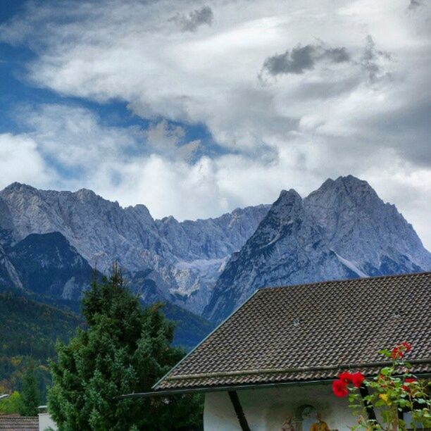 mountain, mountain range, sky, tree, cloud - sky, beauty in nature, scenics, nature, cloud, built structure, tranquil scene, tranquility, architecture, landscape, building exterior, day, cloudy, no people, growth, house