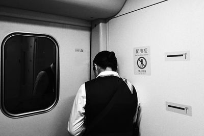 Rear view of man standing against wall