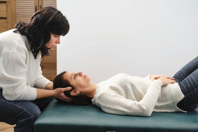 Woman osteopath therapist examining patient head for diagnosis and treatment. professional care and