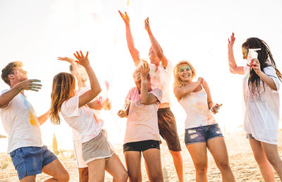 Friends celebrating holi with powder paint at beach