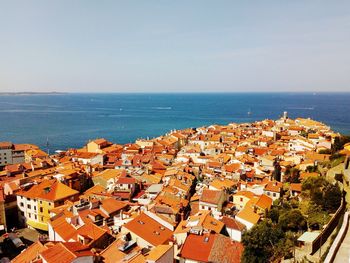 High angle view of townscape by sea against sky