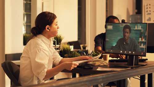 Side view of woman using laptop at home