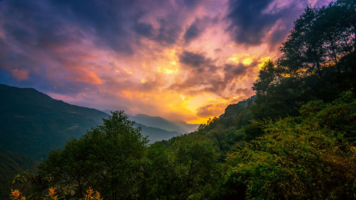 Scenic view of dramatic sky over mountains during sunset