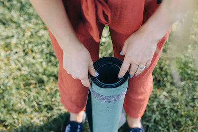 Midsection of woman holdings yoga mat