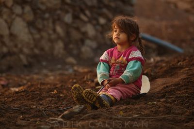 Cute girl sitting on field