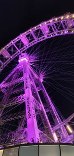 Low angle view of illuminated ferris wheel at night