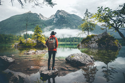 Rear view of woman looking at lake against mountains