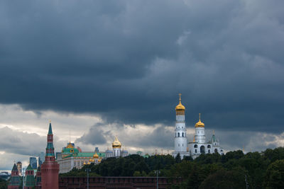 View of buildings in city against cloudy sky