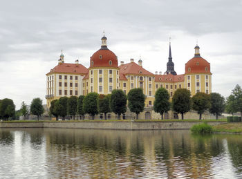 View of buildings and water against cloudy sky