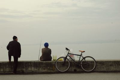 Rear view of people looking at sea against sky