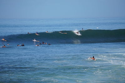 People in sea against sky