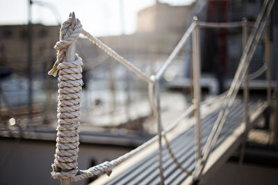 Close-up of rope tied to moored at harbor