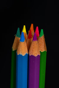 Close-up of multi colored pencils against black background