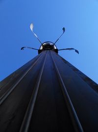 Low angle view of wind turbine against blue sky