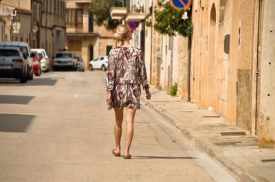 Rear view of woman walking on street in city