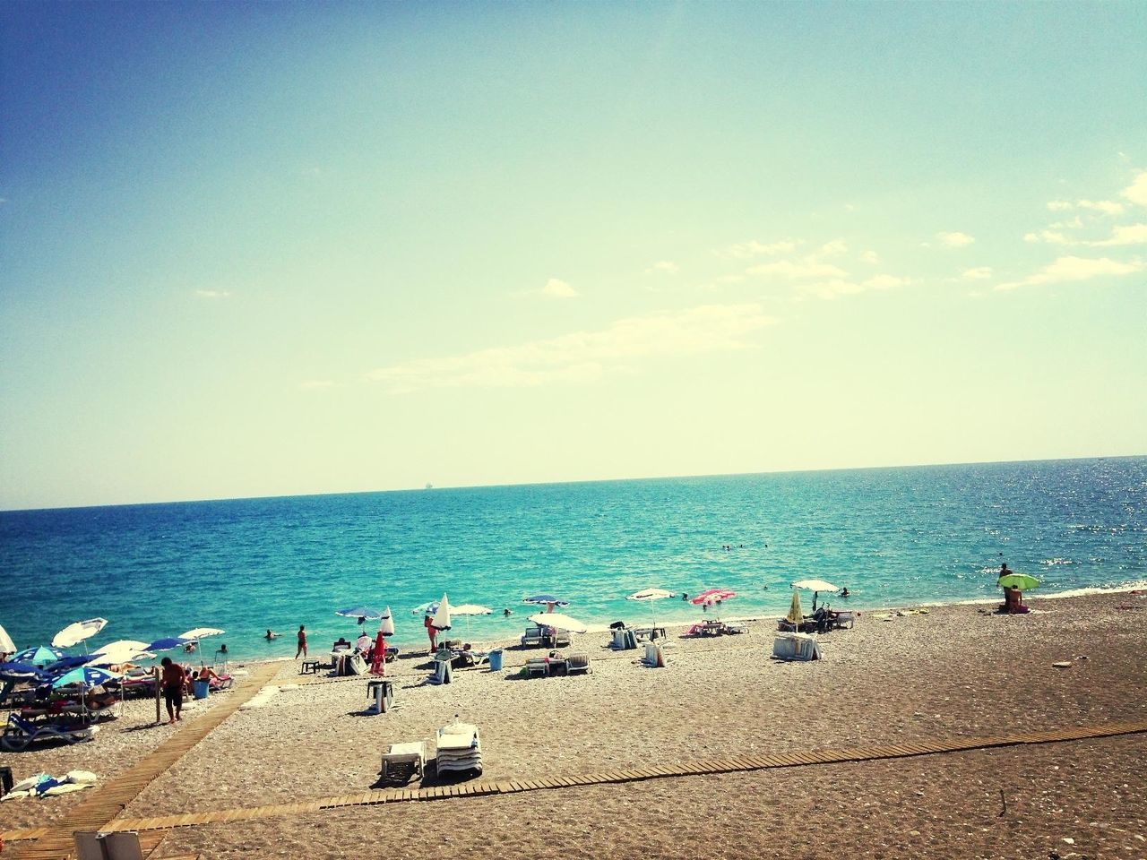 sea, horizon over water, water, beach, large group of people, shore, vacations, sky, blue, leisure activity, scenics, person, lifestyles, beauty in nature, men, nature, tranquil scene, mixed age range, tranquility