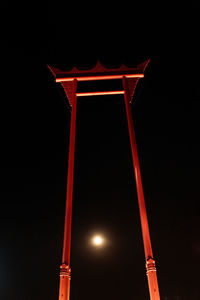 Low angle view of illuminated lamp against sky at night