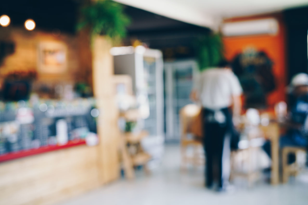 REAR VIEW OF PEOPLE WALKING ON RESTAURANT TABLE