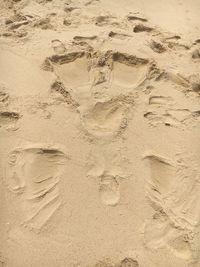 High angle view of footprints on sand at beach