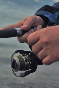 Close-up of person holding fishing rod