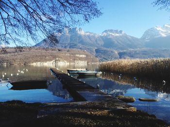 Scenic view of lake by snowcapped mountains against sky