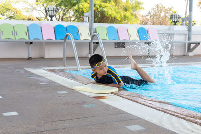 Boy sitting in swimming pool