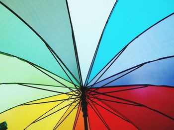 Low angle view of multi colored umbrella against blue sky