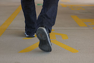 Low section of man walking on road