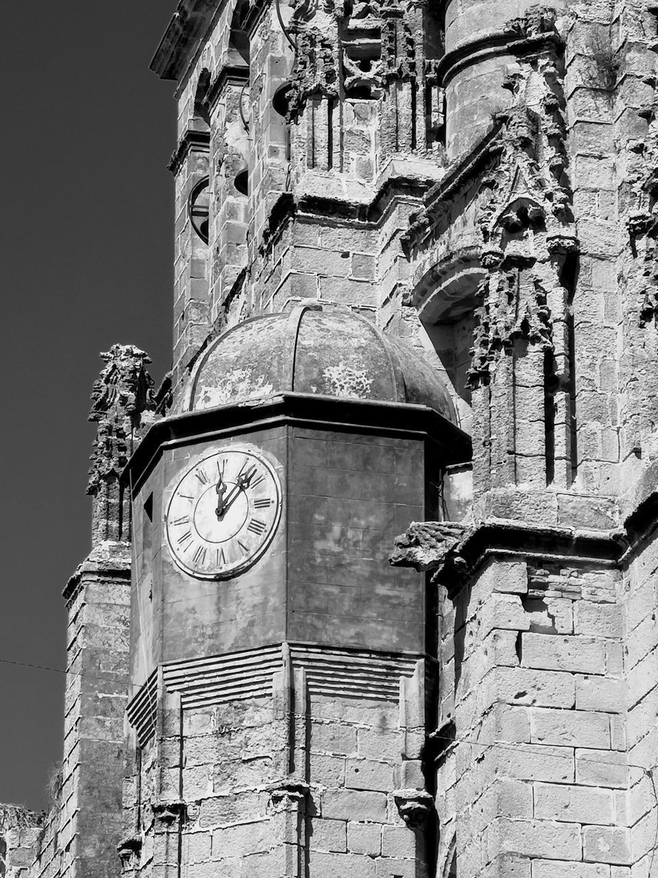 LOW ANGLE VIEW OF OLD CLOCK TOWER AMIDST BUILDING