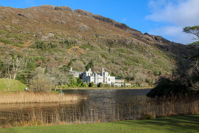 Scenic view of lake by buildings against sky