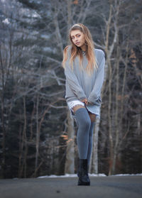 Portrait of beautiful young woman on bare tree